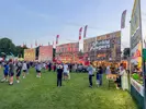 Crowds standing on a lawn in front of food vendors