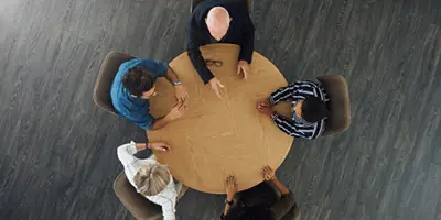 Overhead picture, looking down at 5 people sitting around a round table